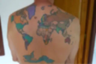 Wereldreiziger heeft wereldkaart tattoo die hij inkleurt